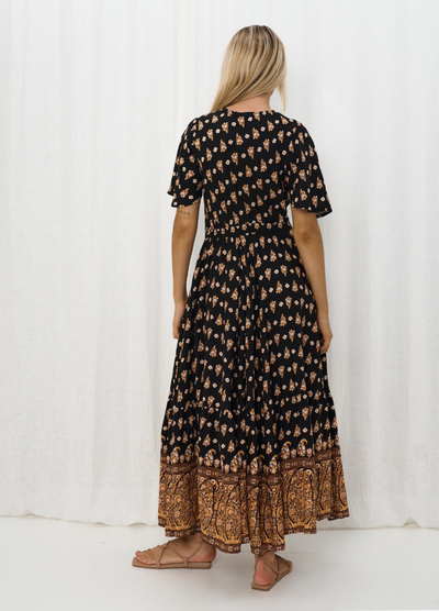 Model wearing the Iris Maxi Gypset Dress in black print with button front and cap sleeve