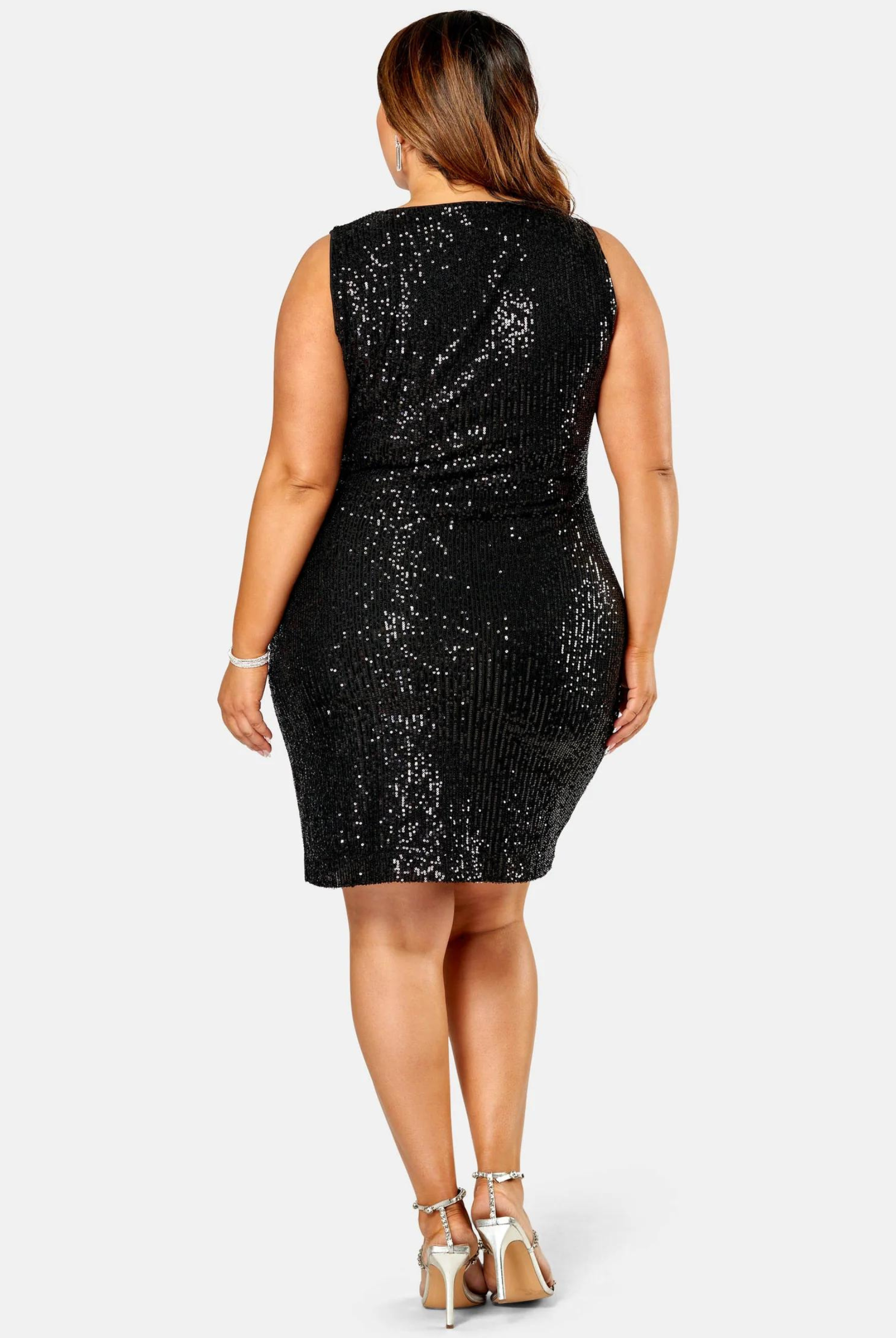 Curve woman wearing a sequin mini dress with wrap front detail