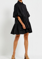 Model wearing the Bohemian Traders black Genoa Dress with button up front