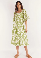 Model wearing the Dulce Midi Dress from Australian Brand Girl in the Sun in green and white lighthouse print