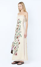 Woman wearing a floral strapless dress on a white background