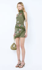 Woman wearing a green floral dress with a white background