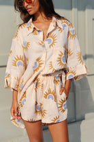 Woman wearing a sun-patterned outfit with a neutral background