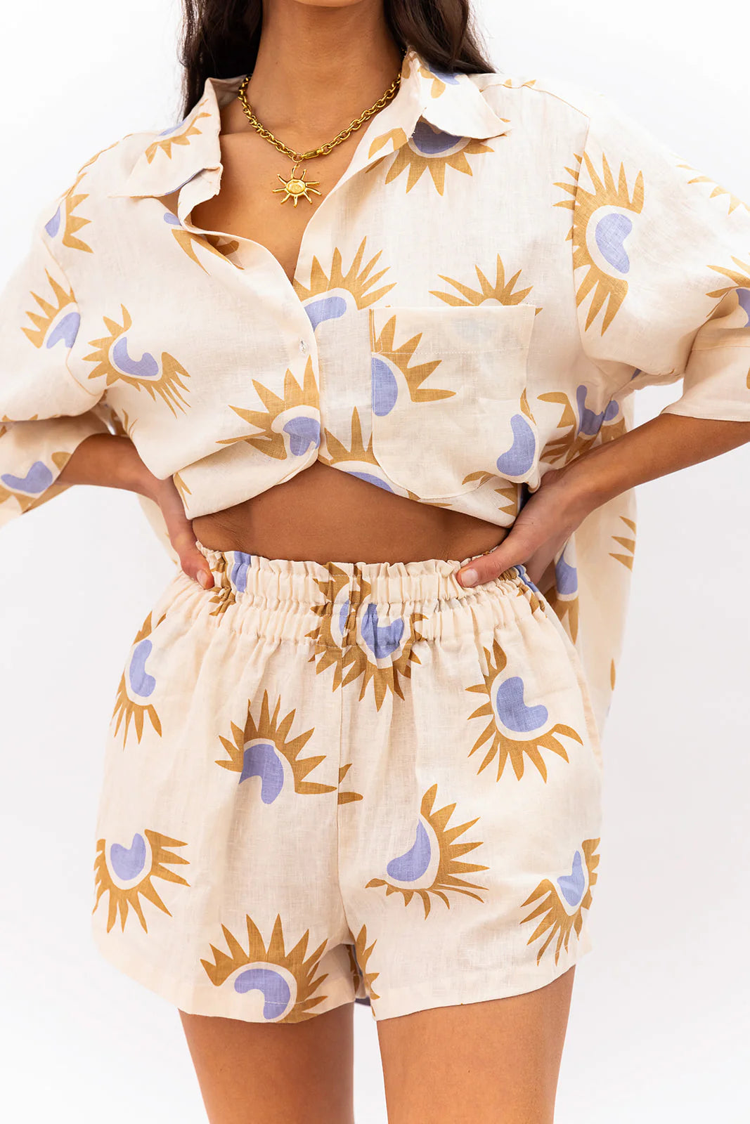 Person wearing a matching top and shorts set with sunflower pattern on a white background