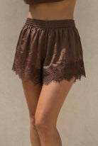 Brown lace-trimmed shorts on a neutral background