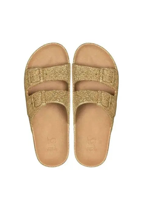 Pair of gold sandals with a white background