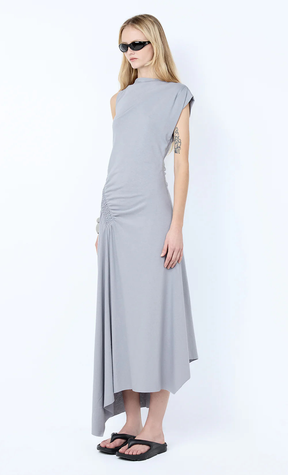 Woman wearing a gray dress with a white background Ema Asym Dress - Grey Blue