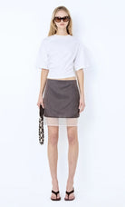 Woman wearing a white top and gray skirt with sunglasses on a white background Ema Asym Tee - Ivory
