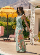 Woman in a floral dress standing outdoors with mountains in the background