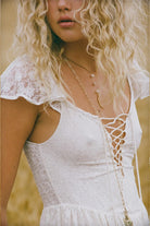 Woman wearing a white lace dress with a blurred background
