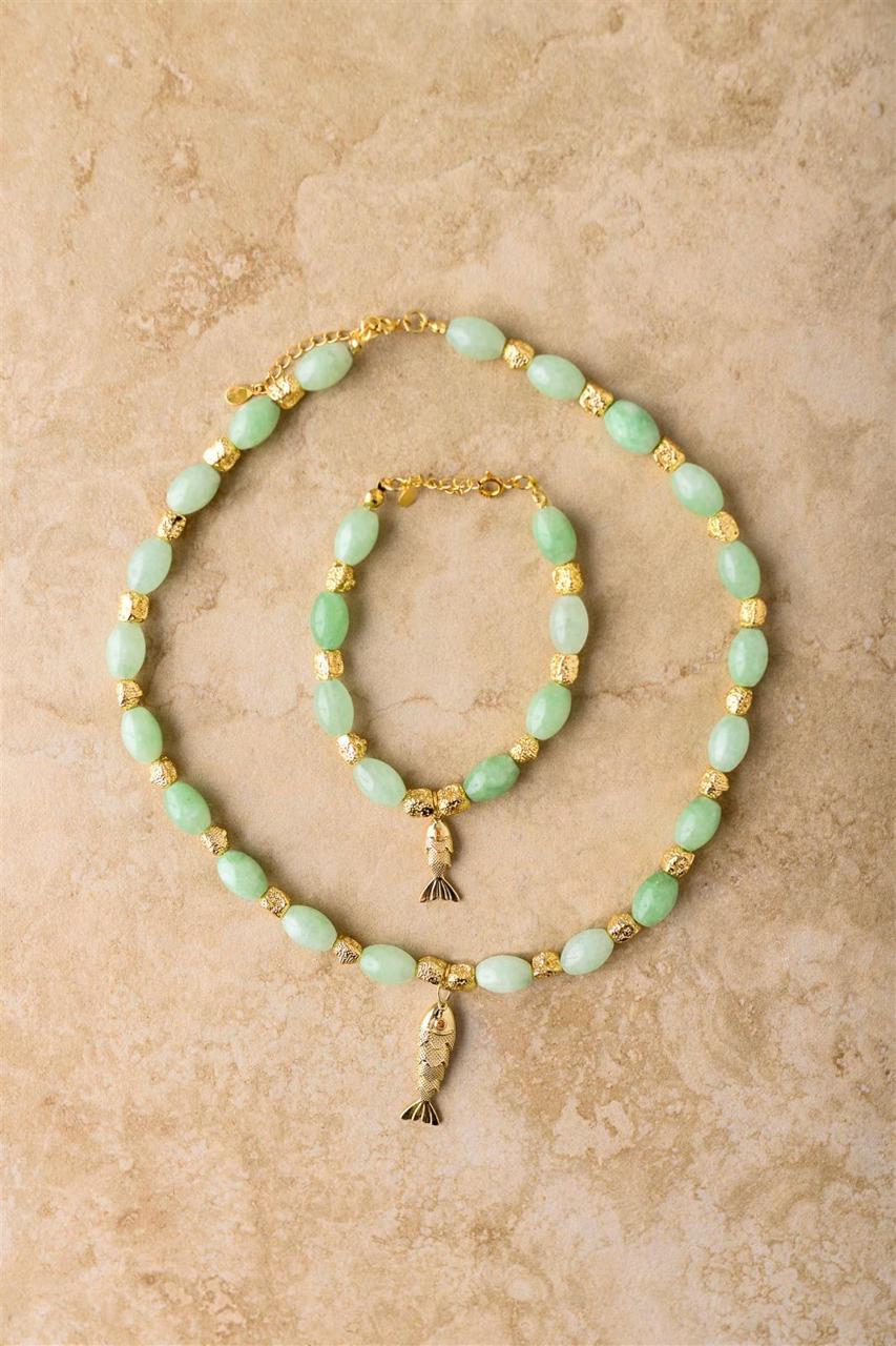 Set of turquoise beaded necklace and bracelet on a beige background