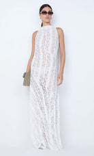 Woman wearing a white lace dress against a white background