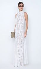 Woman wearing a white lace dress against a white background