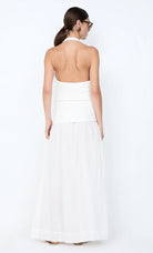 Woman wearing a white strapless dress against a white background