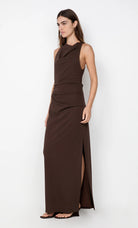 Woman wearing a brown dress with a slit on a white background