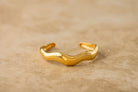 Gold bracelet on a beige background