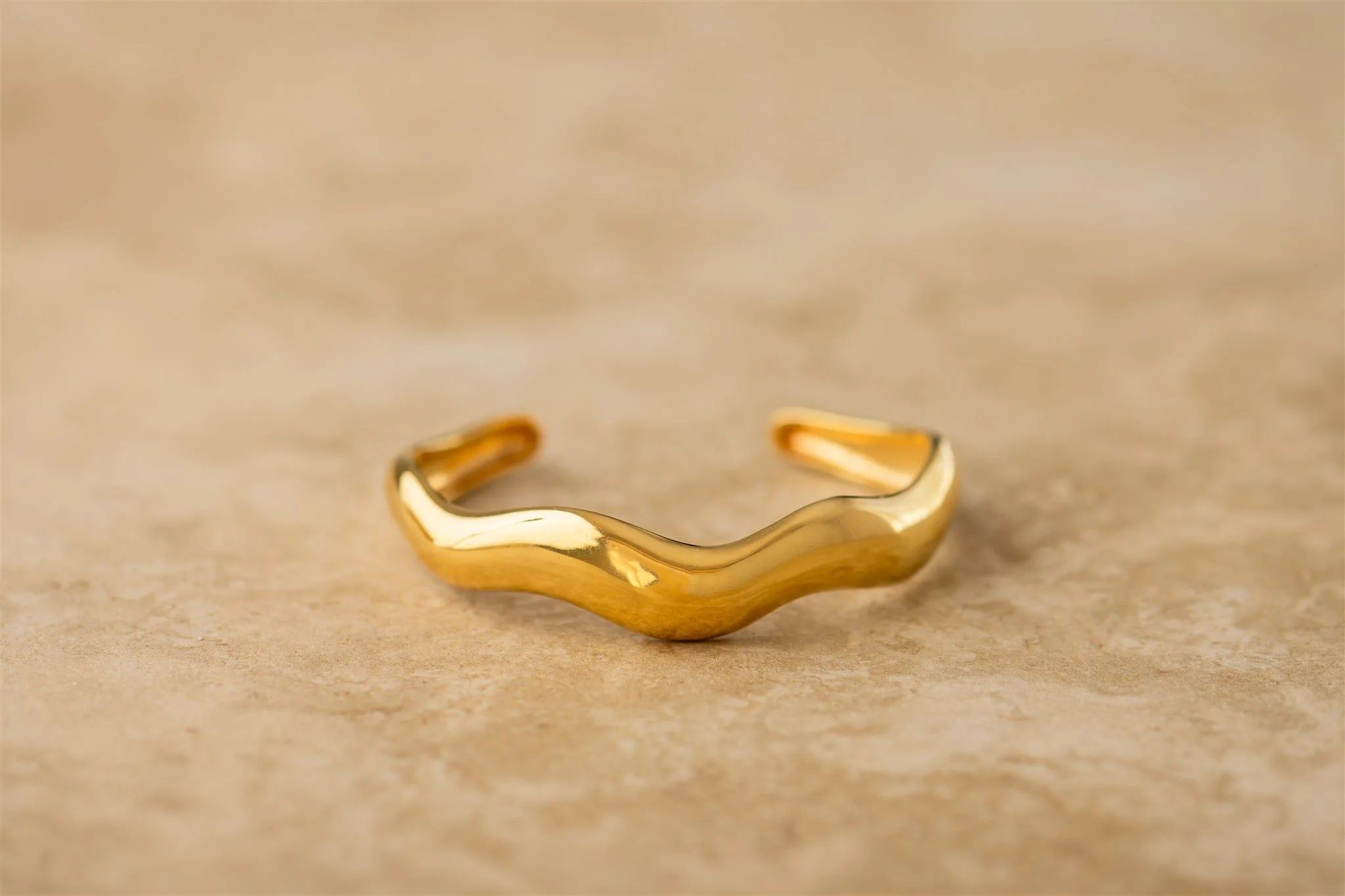 Gold bracelet on a beige background