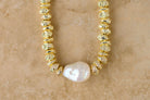 Gold necklace with a pearl on a beige background