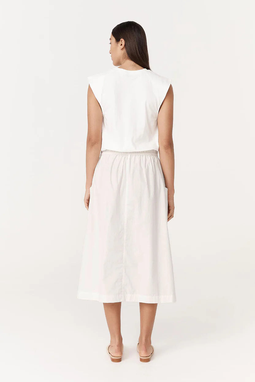 Woman wearing a white sleeveless top and skirt set on a white background