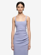 Woman wearing a light purple dress against a white background