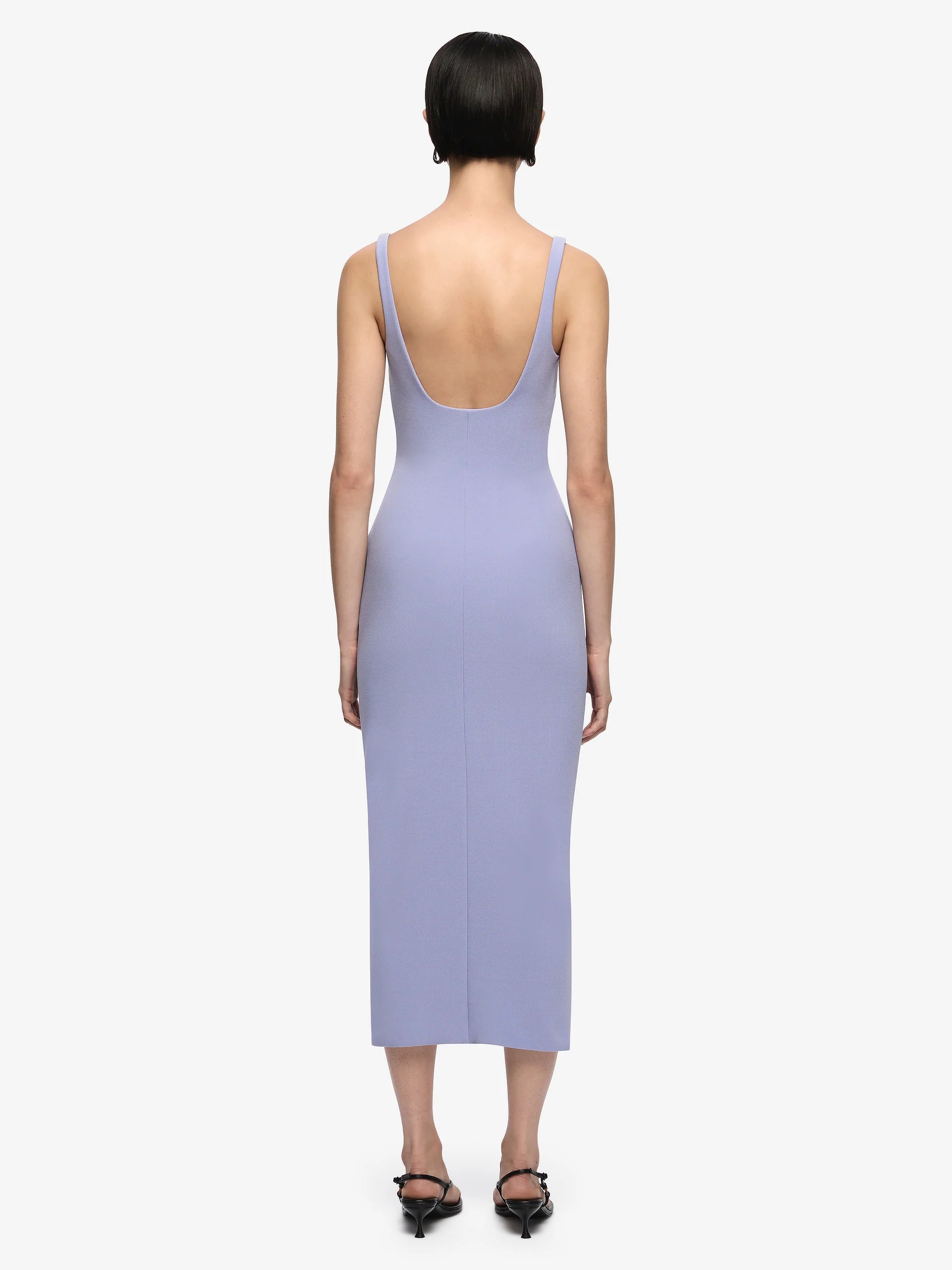 Woman wearing a light purple dress with a plain background