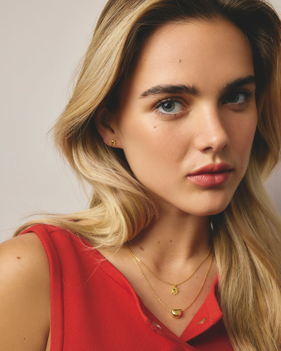 Women wearing gold sunburst necklace 