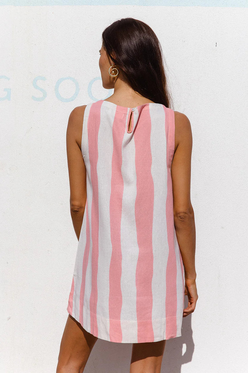 Woman wearing a pink and white striped dress against a white background