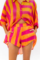 Person wearing a bright pink and orange striped outfit on a white background