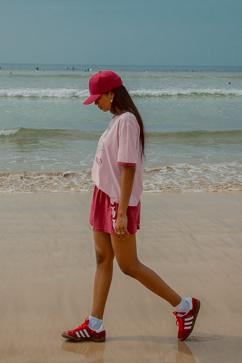 Pink tee shot on a beach from Palm Collective