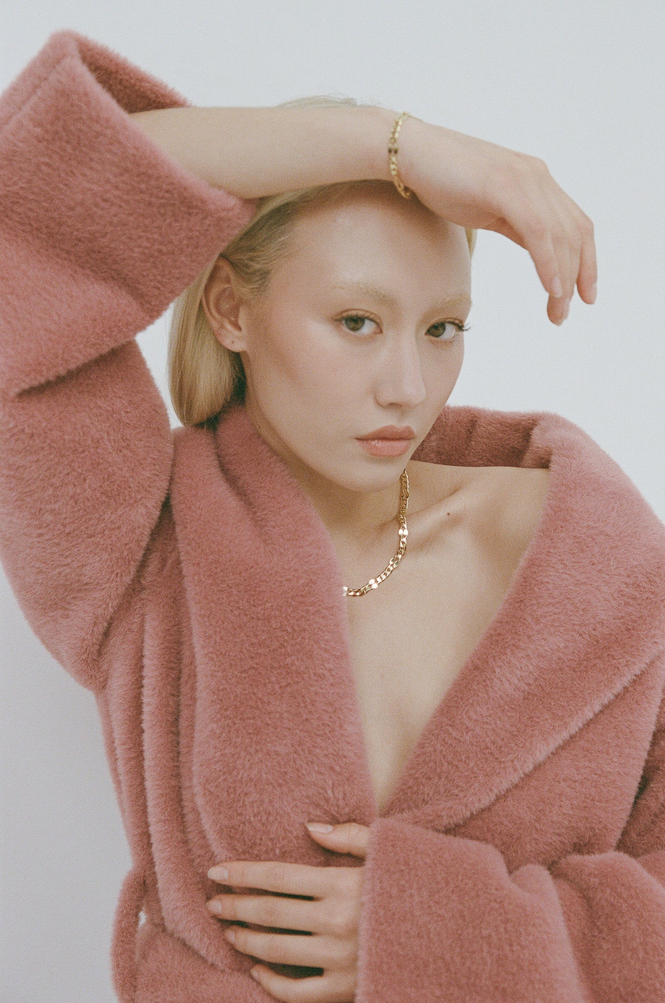 Woman wearing a pink robe with a plain background