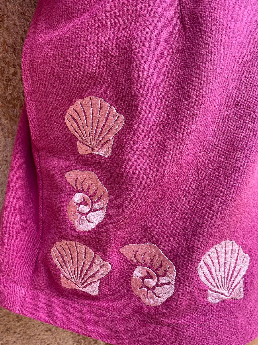 Pink fabric with shell patterns on a textured surface