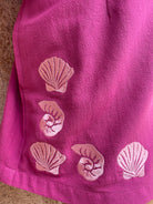 Pink fabric with shell patterns on a textured surface