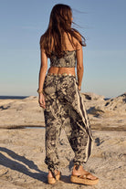 Woman in patterned outfit standing on a rocky beach