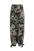 Black pants with a gold floral pattern on a white background
