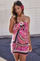 Woman wearing a pink floral dress with a white background