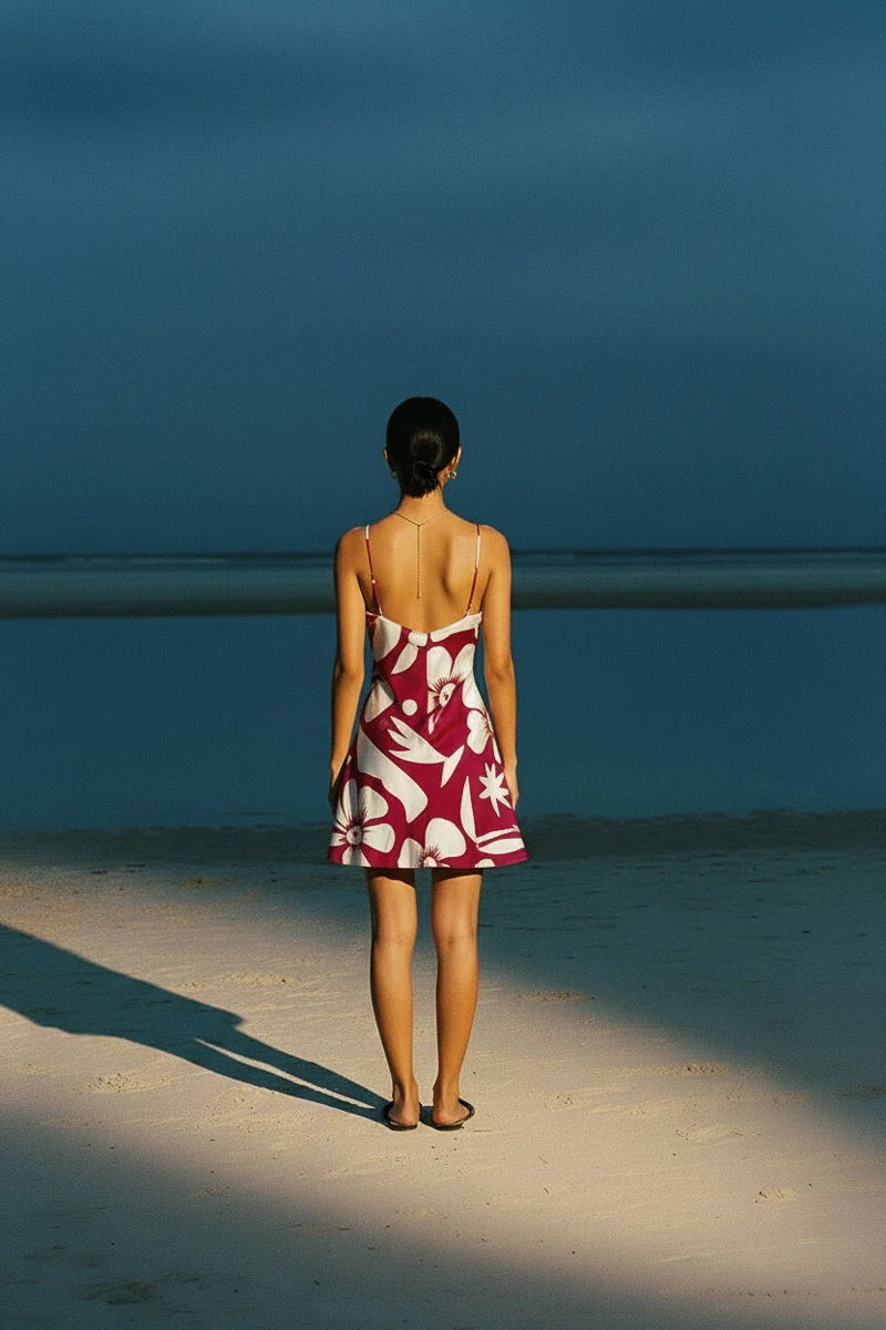 Tahiti mini slip dress from palm collective on a dark skin model against a peach wall. 