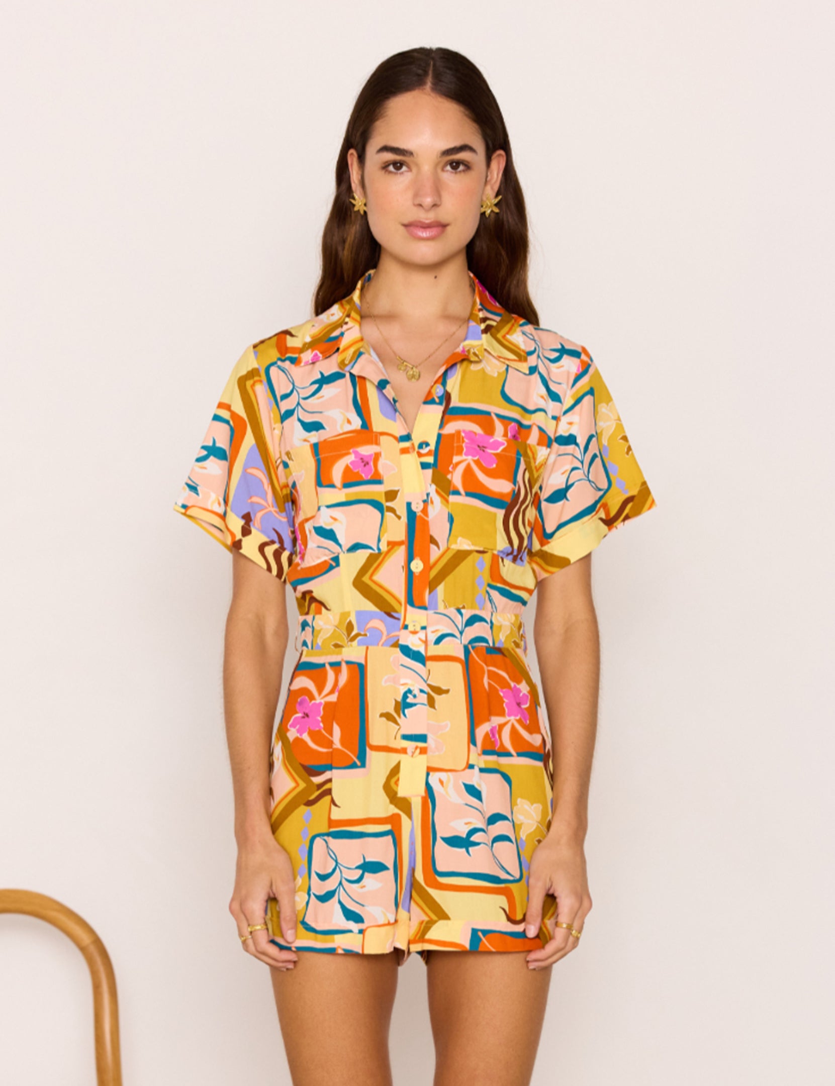 Woman wearing a colorful patterned dress against a plain background