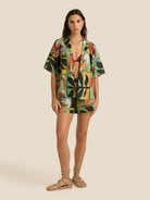 Woman wearing a colorful abstract patterned outfit on a beige background