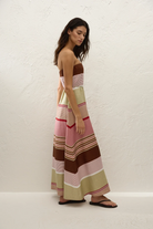 Woman wearing a colorful striped dress against a white background