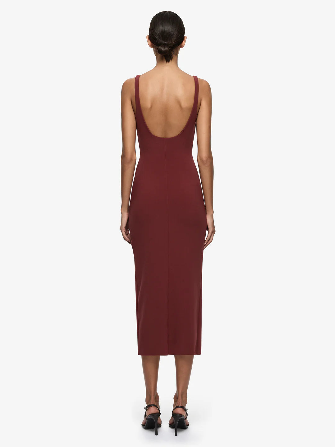 Woman wearing a burgundy dress with a deep neckline on a white background