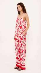 Woman wearing a red and white floral dress on a white background