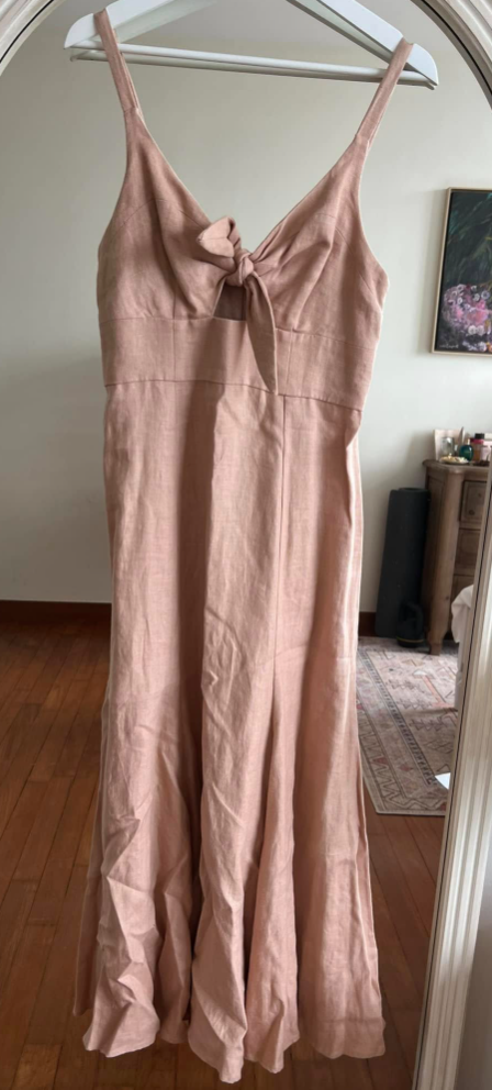 Pink dress hanging on a hanger in front of a mirror