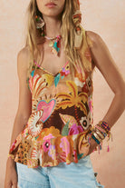 Woman wearing a colorful floral top with a plain background