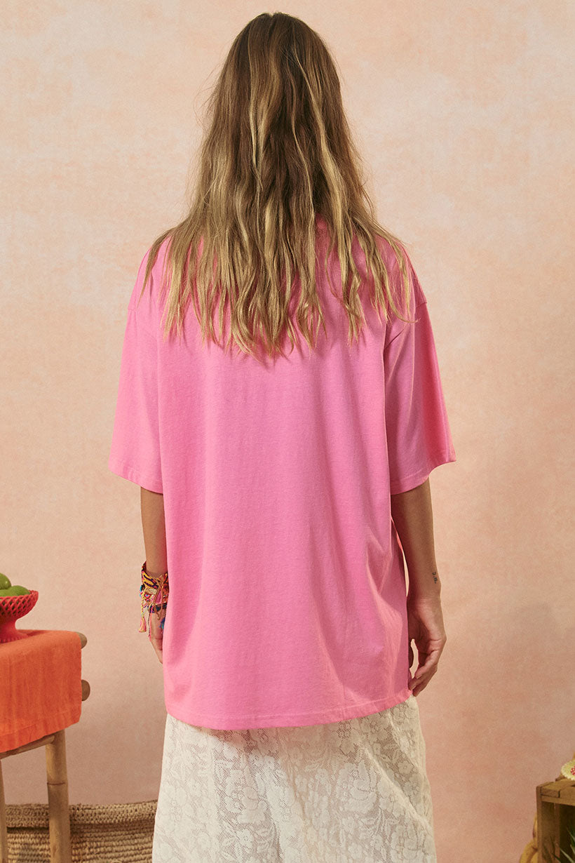 Person wearing a pink shirt with a neutral background
