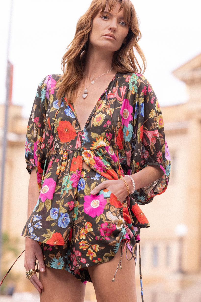 Woman wearing a colorful floral dress with a blurred background