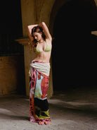 Woman in a colorful outfit standing in a sunlit archway
