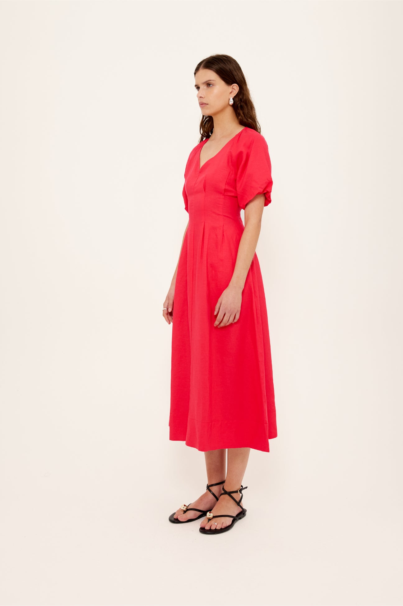Woman wearing a bright pink dress on a white background