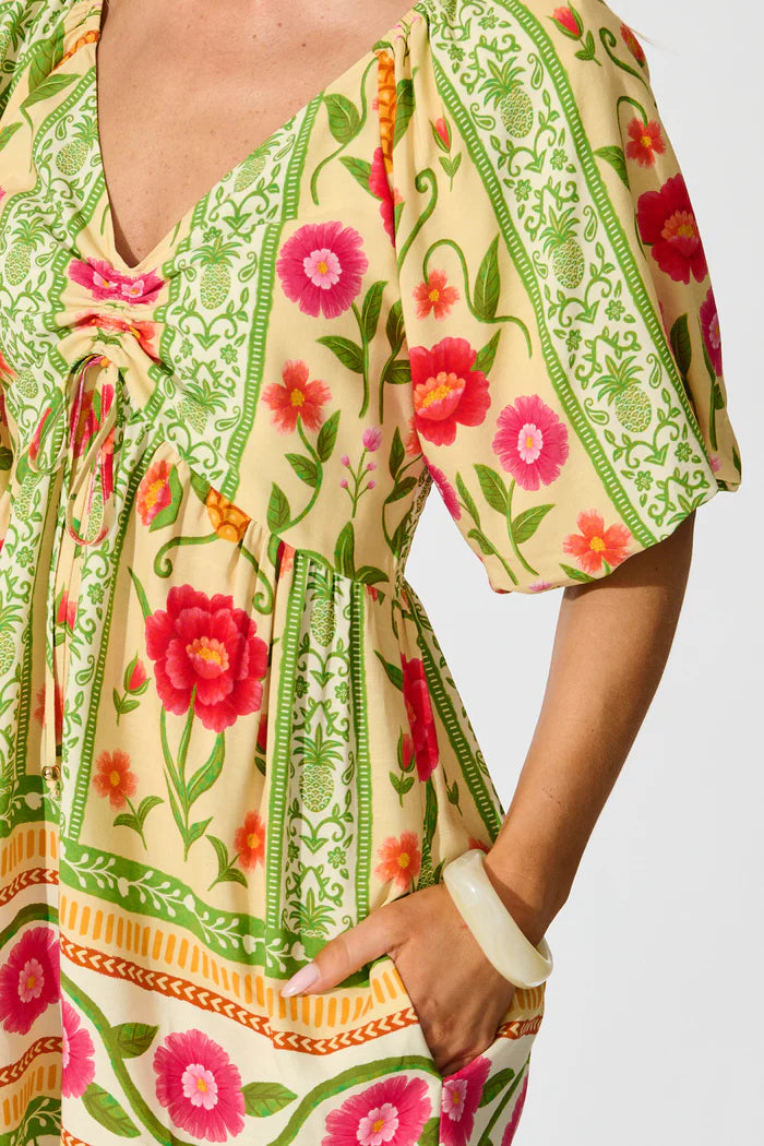 Colorful floral dress with green patterns on a plain background