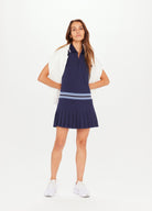 Navy blue tennis dress with button through and stand collar featuring a pleated skirt