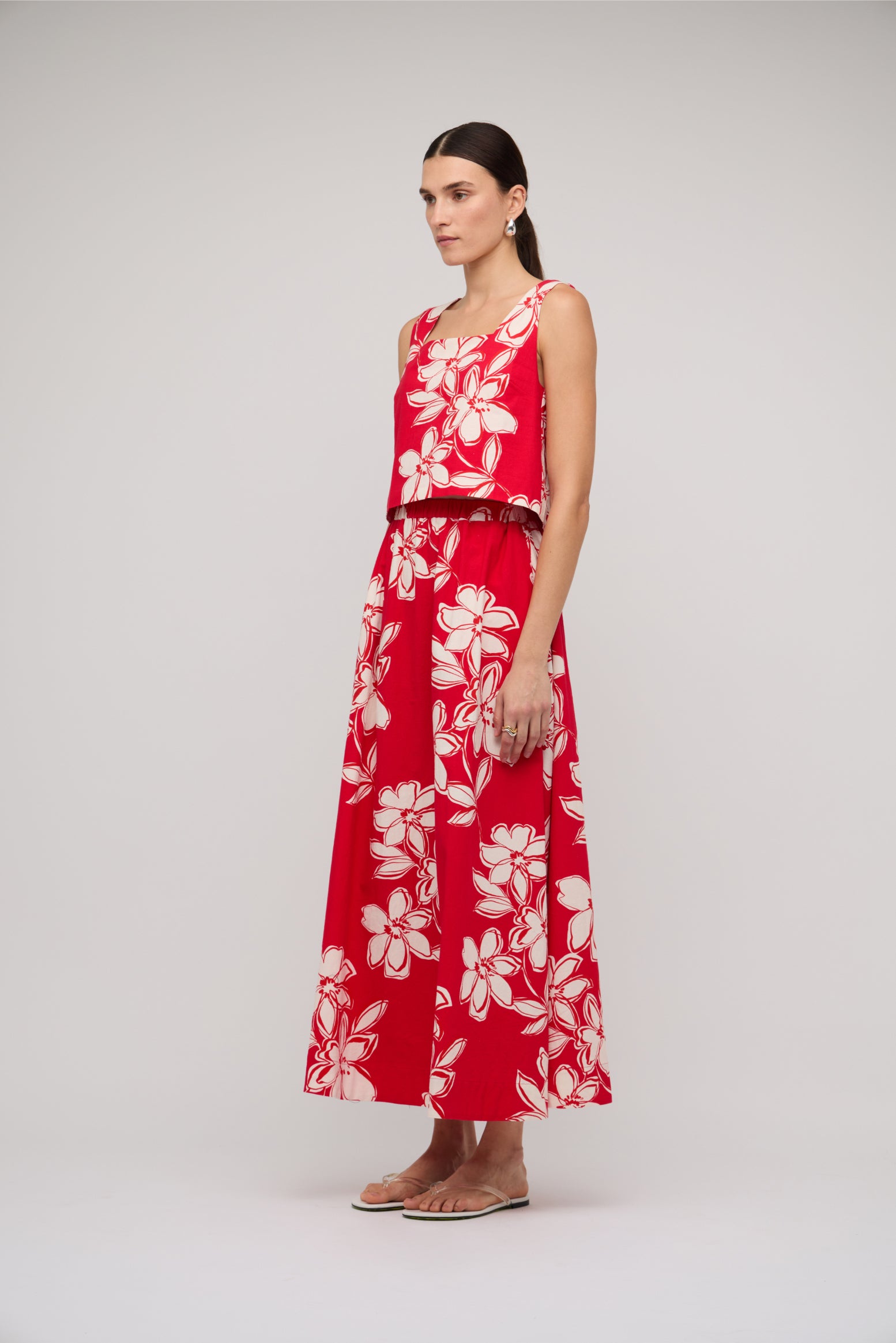 Woman wearing a red floral dress on a white background